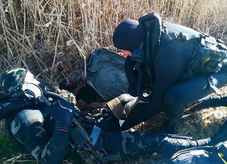 Trauma Bandage 54"x4" Elastic Wrap 4"x7" Non-Adherent Absorbent Pad being used in a field training exercise to stop bleeding on the person's thigh.