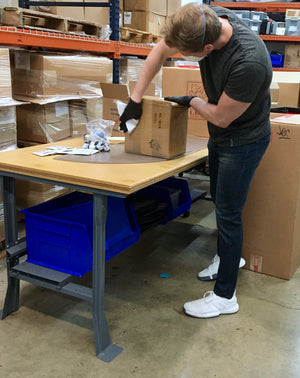 One of our production workers wearing gloves and a mask as he sanitizes incoming deliveries.