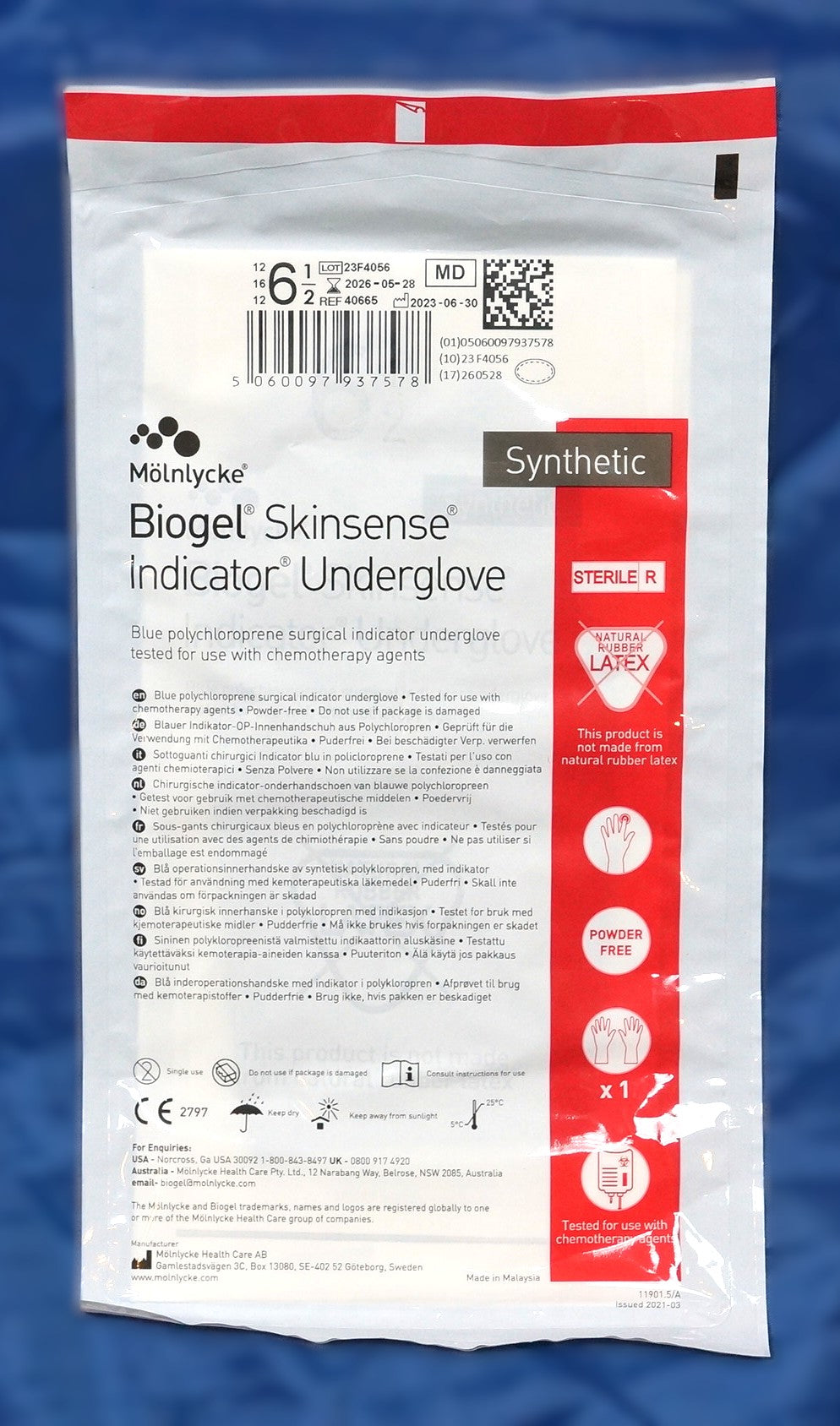 Mölnlycke Biogel Skinsense Indicator Underglove size 6.5 in a white and red sterile package, displayed against a blue textured background.
